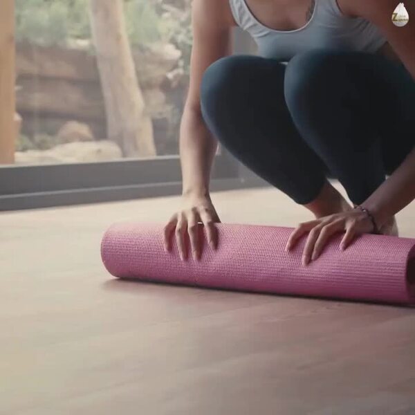 Yoga mat rolled out near a large bright window